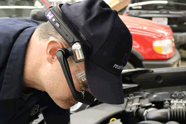 Engineer using data glasses when building a vehicle engine.